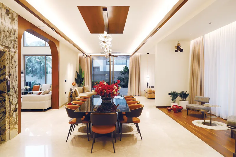 Comedor con mesa de mármol negro, plafón de madera y candil escultórico de cristal